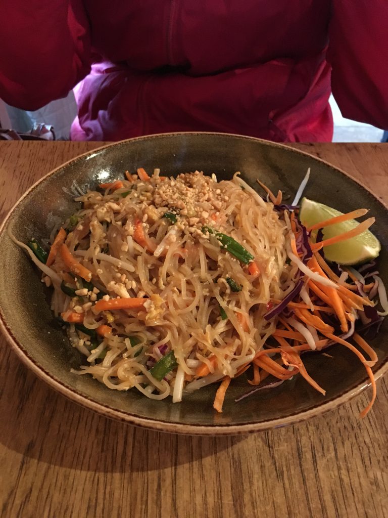 A vegetarian dish with lots of noodles, carrots and cabbage.