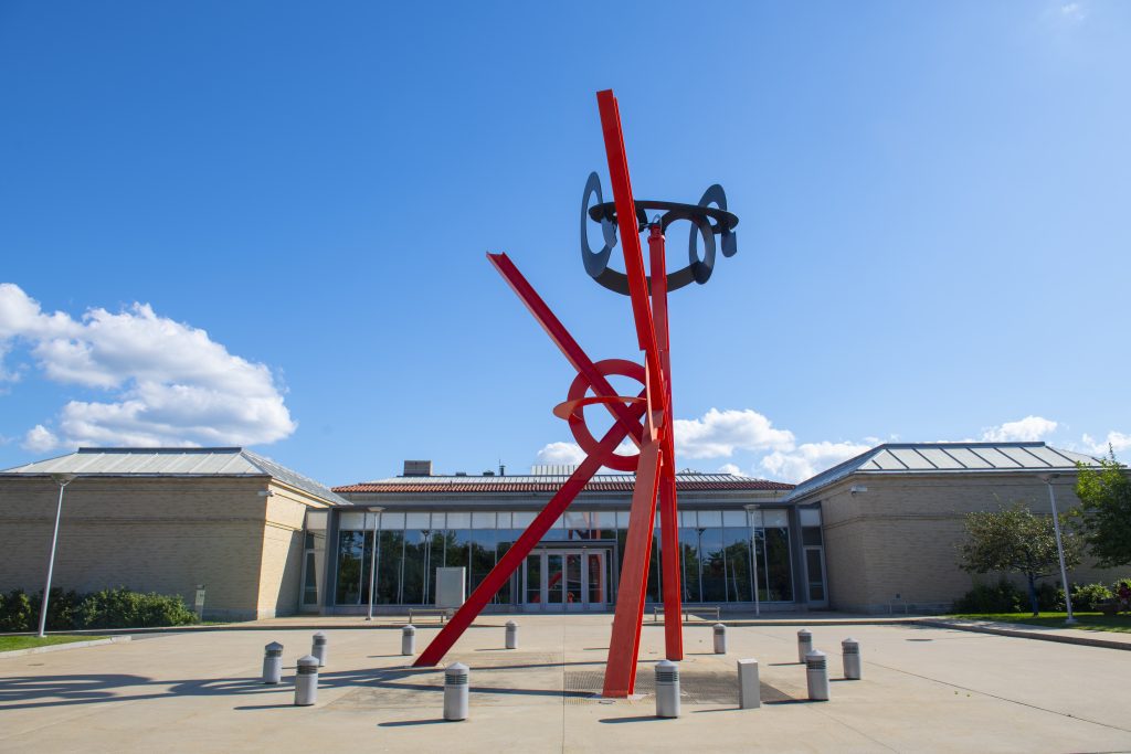 A red and black sculpture made of metal beams outside the Currier Museum.