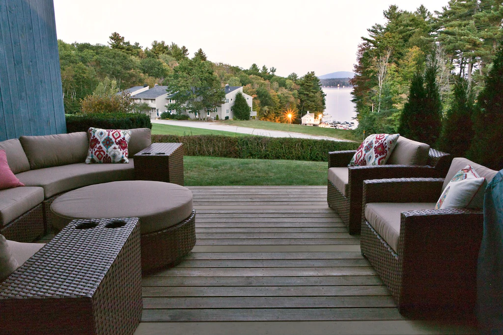 A lakeview from a wooden deck with furniture