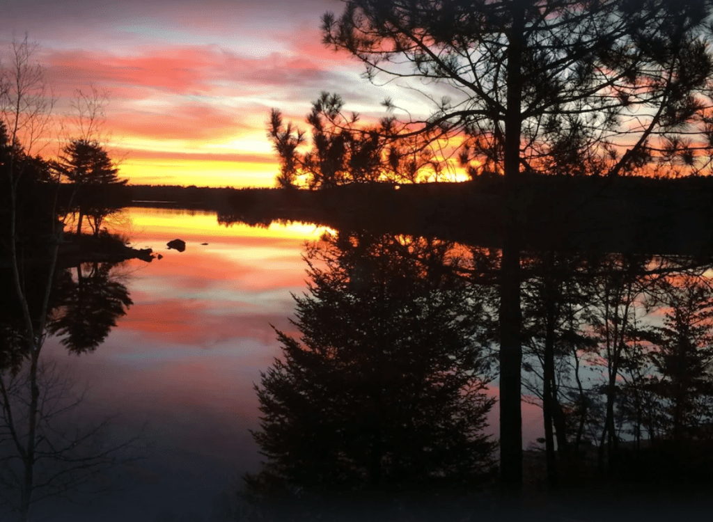 Beautiful sunset reflected into the water on Little Lake Sunapee