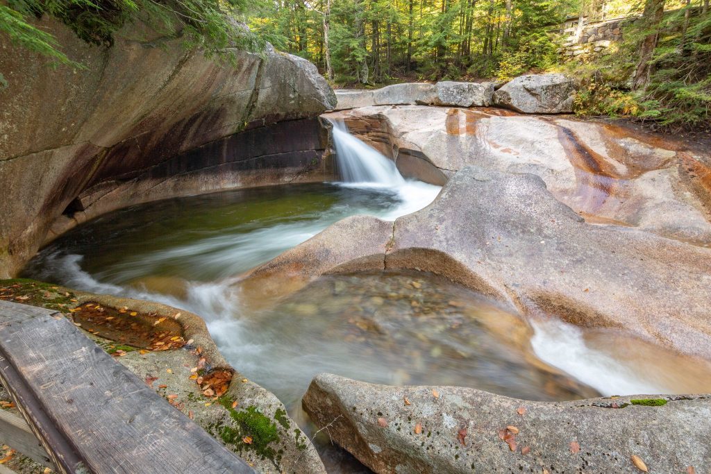A granite pool with a waterfall feeding into it and spinning around in slow motion.
