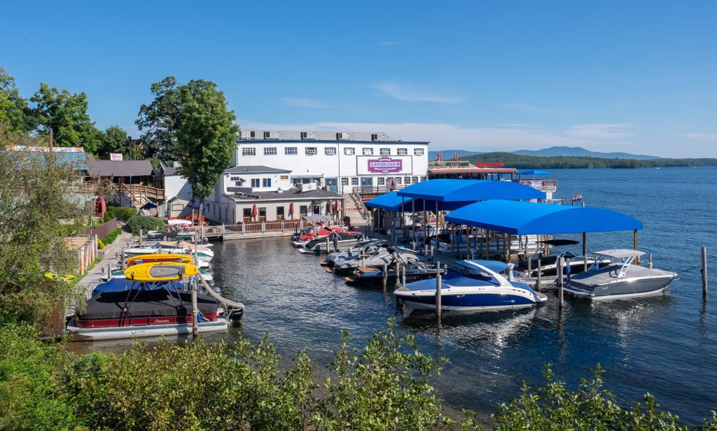 Boats docked on a pier on a calm blue lake.