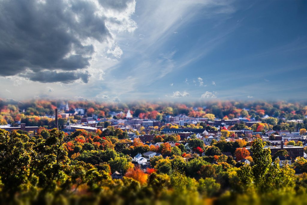 Aerial view of Dover NH on a bright but cloudy morning with trees in the foreground