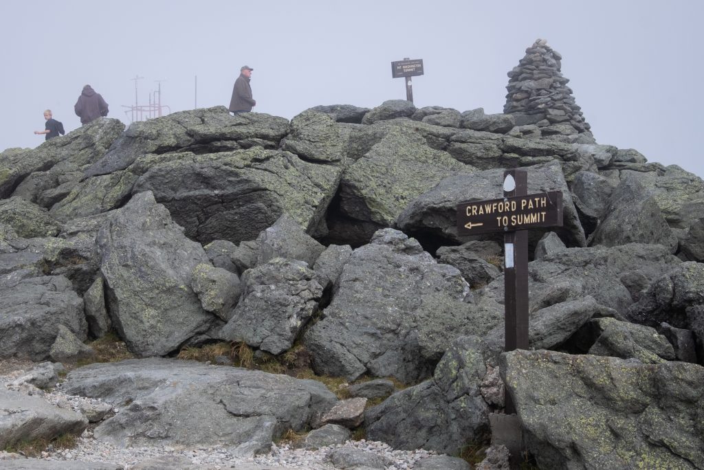 A rocky area with a sign reading Crawford Path to Summit.