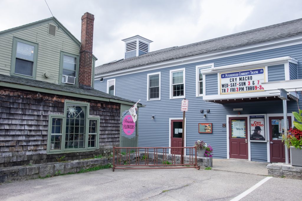 Two buildings in Peterborough -- one with weatherbeaten wooden shutters, and a building that looks like a blue house but is actually the Peterborough Community Theatre and puts on movies.