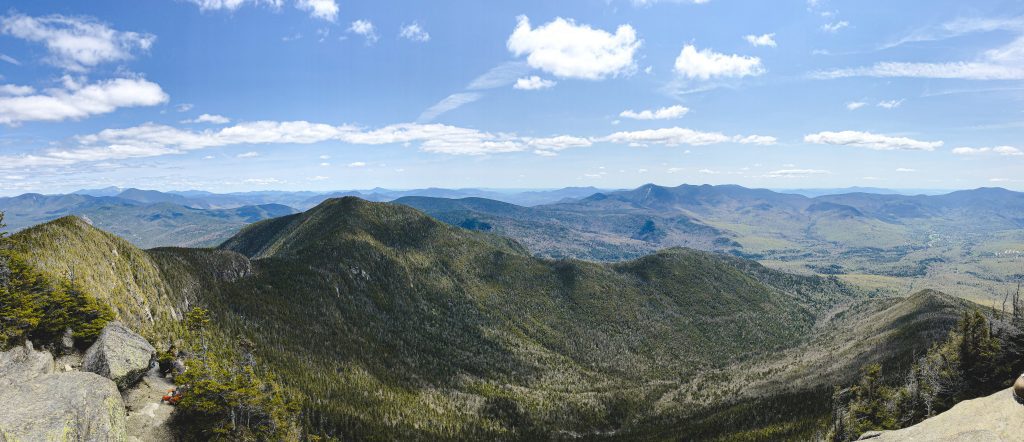 View of endless rolling green mountains beneath a partly cloudy sky.