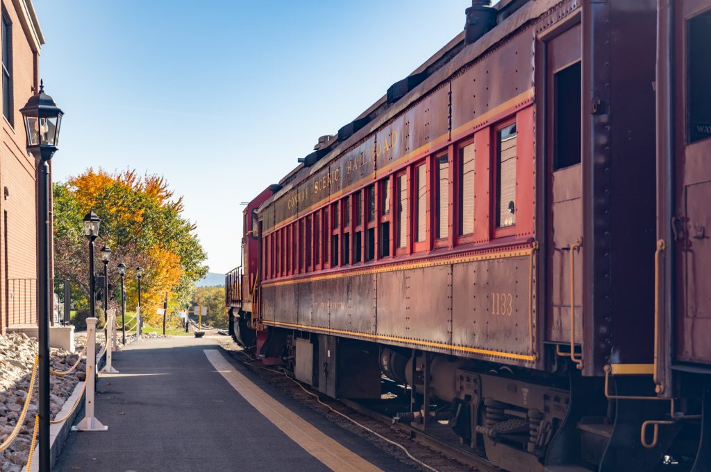 A shiny maroon train parked at a station.