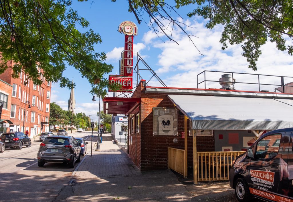 A city street with the Red Arrow Diner in the foreground.