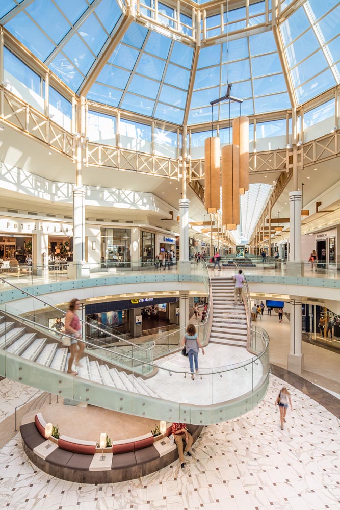A shopping mall with a giant skylight and a spiral staircase.